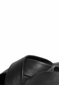 Crne kožne sandale s širokim, mekim trakama. Imaju glatku teksturu i minimalistički dizajn, s zaobljenim oblikom i preklapajućim trakama.