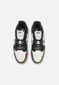 Nike sportcipők fekete, fehér és olíva színkombinációval, hálós és bőrmaterialból, perforált orr résszel és �állítható pánttal.