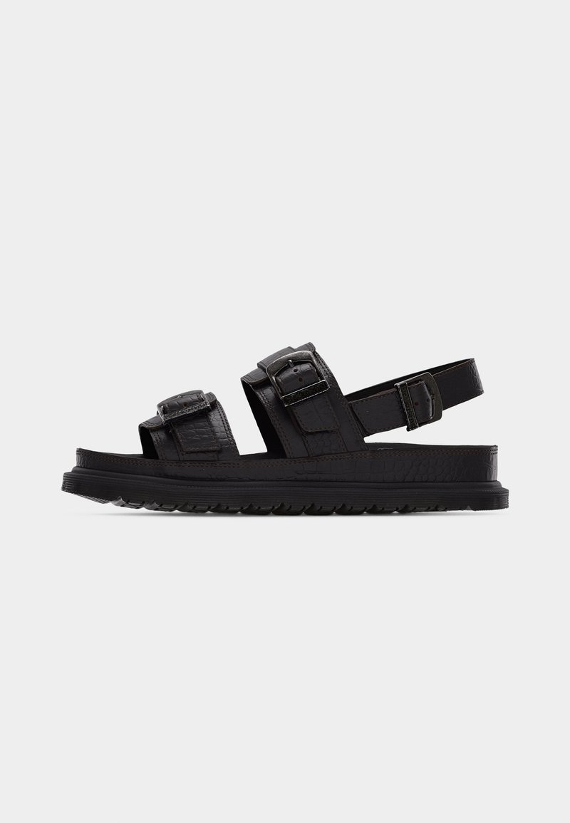 Black leather sandal with three adjustable straps, two with buckles across the foot, one around the heel, and a textured sole.