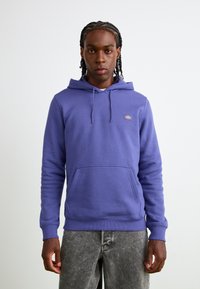 Hoodie violet en mélange de coton, avec une poche kangourou, une capuche à cordon, des poignets côtelés et un petit logo brodé sur la poitrine.
