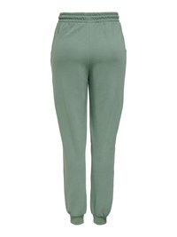 Pantalon de jogging vert clair en tissu doux, avec une taille et des poignets élastiques, deux poches latérales et une coupe décontractée.