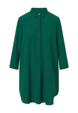 Zöld, galléros tunikaing, háromnegyedes ujjakkal, sima textúrával, elől gombos záródással és enyhén ívelt szegéllyel.