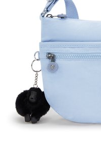 Borsa di tessuto blu chiaro dalla forma arrotondata, con una tasca con zip e un charm in pelliccia nera a forma di gorilla attaccato alla cerniera.