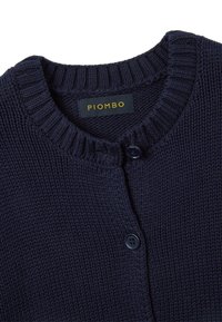 Cardigan lavorato a maglia di colore blu navy con colletto a coste e chiusura a bottoni. Presenta un tessuto texturizzato e un'etichetta con "PIOMBO" in giallo su uno sfondo scuro.