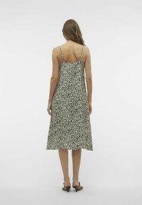 Midi sukienka w czarno-kremowy wzór z cienkimi ramiączkami i zwiewnym krojem, charakteryzująca się luźnym fasonem i gładkim materiałem.