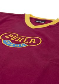 Bordeaux T-shirt met een gele V-hals. Bevat een geborduurd logo met "DUKLA" in het geel en "PRAHA" in het blauw.
