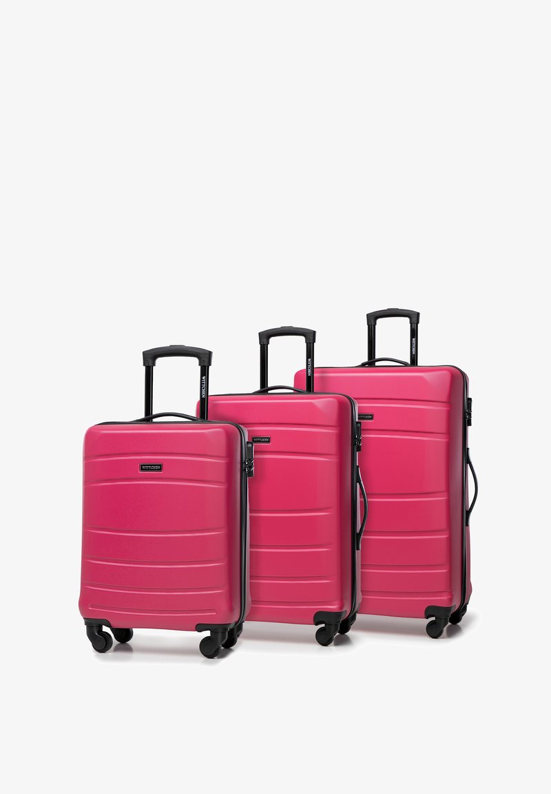 Set di tre valigie rigide di colore rosa acceso, caratterizzate da una superficie testurizzata, ruote nere girevoli e manici estensibili per un facile trasporto.
