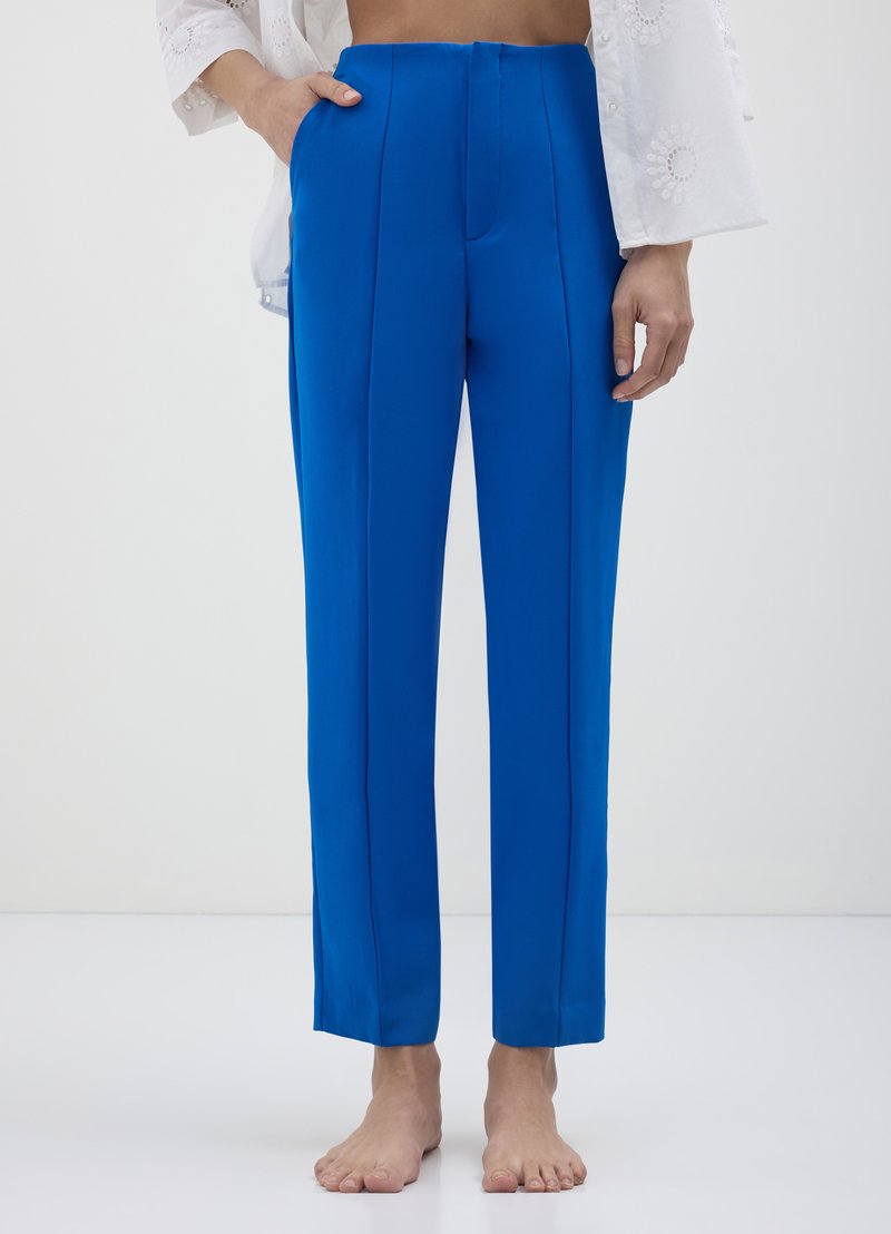 Pantalons bleu vif avec une coupe droite, des plis sur le devant et une texture lisse. Présente des poches sur les côtés et un design épuré et minimaliste.