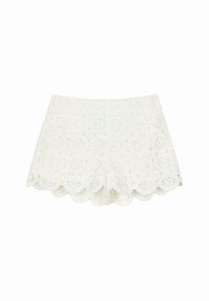 Biele čipkované šortky s kvetinovým výrezom, vlnkovaným lemom a hladkou textúrou. Predné zapínanie bez viditeľných kovových detailov.