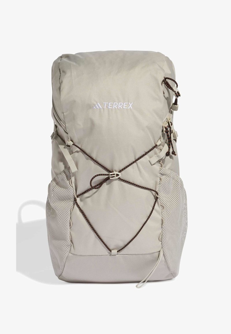 Zaino Terrex in beige chiaro, con tessuto testurizzato, chiusura con cordino, tasche laterali in rete e logo sulla parte anteriore.