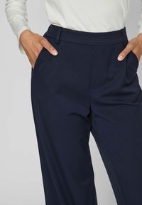 Marinblå skräddarsydda byxor i slät tyg med sidofickor, midjeband med bälteshällor och rak benprofil.