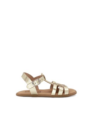 Platte open-toe gouden sandaal met meerdere bandjes en een verstelbare gesp enkelband op een bruine zool.