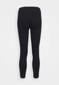 Černé legíny vyrobené z pružného materiálu, s vysokým pasem a švy podél nohavic. Hladký povrch, přiléhavý střih.