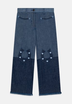 Jean en denim à design bicolore avec une partie supérieure plus claire et une partie inférieure plus foncée. Broderie en forme de fer à cheval avec des coeurs. Ourlet effiloché.