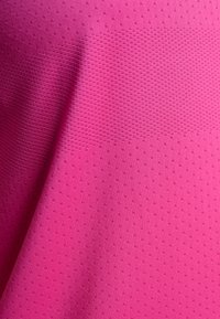 Textil de color rosa brillante con una superficie texturizada que presenta pequeños perforaciones regulares. El material parece ligero y ligeramente elástico.