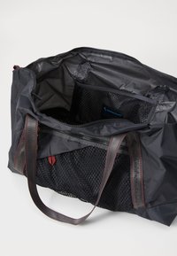 Schwarze Nylontasche mit grauen Mesh-Taschen im Inneren. Verfügt über doppelte Stoffgriffe und einen Reißverschluss. Das Innere hat eine glatte, wasserabweisende Beschichtung.