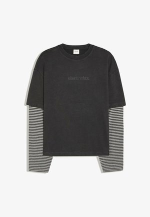 Schwarzes T-Shirt mit kurzen Ärmeln, über einem grau-schwarz horizontal gestreiften Langarmshirt getragen, mit kleinem gepunktetem Text "silent notes" auf der Brust.