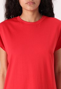 Rotes Kurzarm-T-Shirt mit Rundhalsausschnitt, aus weichem Stoff, mit glatter Textur und lässiger Passform. Keine sichtbaren Muster oder Akzente.