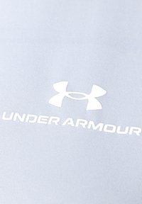 Tessuto atletico azzurro chiaro con il logo bianco di Under Armour, con il nome del brand ben visibile sotto il logo.