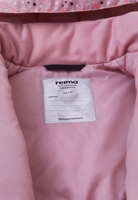 Rosa Stoffinneneinrichtung mit dekorativen Blumen, einem Etikett mit dem Markennamen "Reima", wetterfesten Details und der Größe "104 / 4T."