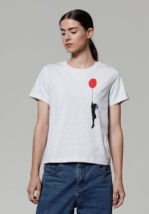 Graues Baumwoll-T-Shirt mit einer schwarzen Silhouette eines Kindes, das einen roten Luftballon hält. Rundhalsausschnitt, kurze Ärmel und lässige Passform.