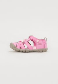 Pink sandal with breathable fabric upper, adjustable straps, and a gray rubber sole featuring grooves for traction.
