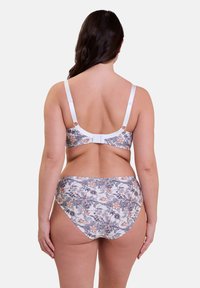Conjunto de bikini con estampado floral y base blanca, que cuenta con acentos en púrpura y naranja. La parte superior tiene tirantes ajustables y un cierre de gancho y ojo.