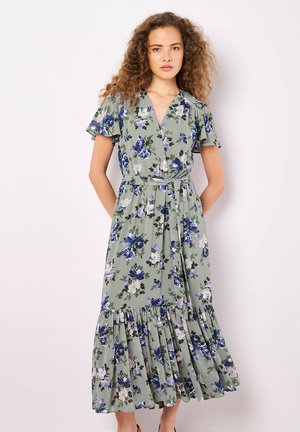 Floral midi dress in light green fabric with purple and white flowers. Features short ruffled sleeves, a wrap design, and a tiered hemline.