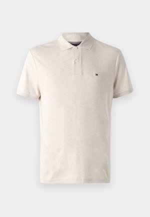 Beige korte mouw polo met twee knopen en een klein rechthoekig vlaglogo aan de linkerborstzijde.