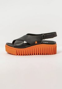 Sandale noire avec des straps croisées, dotée d'une semelle plateforme nervurée orange. Comprend une sangle arrière pour le soutien et une surface texturée.