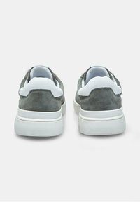 Hallid hallid suveketsid valgete aktsentidega, millel on paks tall ja pehmendatud krae mugavuse tagamiseks. "FLEXIFIT" logo kand on.