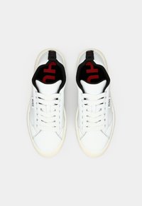 Valged nahast sneakerid mustade ja punaste aktsentidega krael, valgete paeltega ning külje peal on peen logo detail.