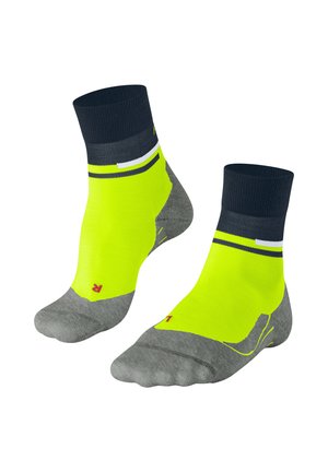 Calzini alla caviglia gialli e grigi con un bordo a coste blu navy, caratterizzati da un design a righe e un logo rosso sulla parte inferiore.