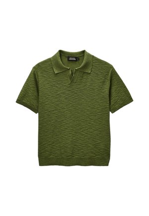 Polo vert en maille texturée à manches courtes, avec col et encolure en V ouverte, taille moyenne, posé à plat sur fond blanc.