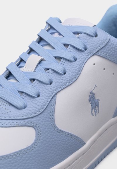 Svetlo modri in beli usnjeni supergi z usklajeno modro vezalko in vezenim logotipom igralca polo na stranski plošči.