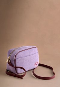 Fialová manšestrová kabelka přes rameno se zlatým zipem, vínovými doplňky a červeným vyšívaným detailem, s nastavitelným popruhem.