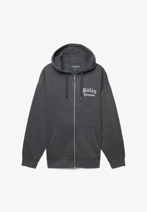 Felpa con cerniera oversize di colore grigio scuro, dotata di tasche frontali, cappuccio con coulisse e testo bianco "Regole Sconosciute" sul lato sinistro del petto.