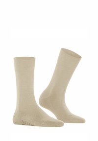 Calzini in cotone beige con una superficie liscia, polsini a coste e punta e tallone rinforzati. Etichetta del marchio stampata sul lato. Lunghezza classica alla caviglia.