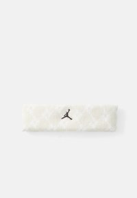Béžová pletená čelenka so subtílnym bielym vzorom a čiernym vyšitým logom Jumpman umiestneným na bielom pozadí.