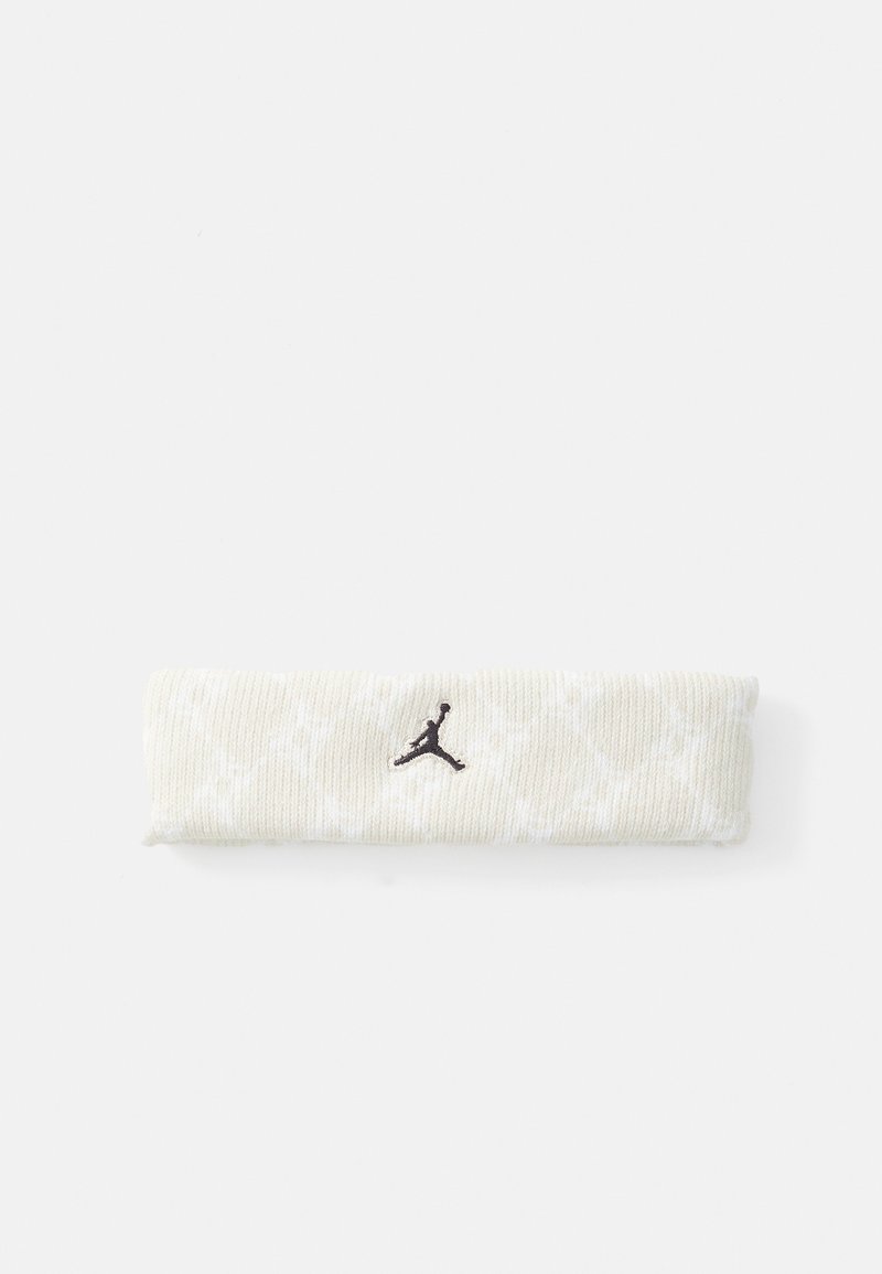Béžová pletená čelenka so subtílnym bielym vzorom a čiernym vyšitým logom Jumpman umiestneným na bielom pozadí.