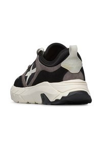 Sneaker in materiali misti nero e grigio con logo bianco, dettagli testurizzati, suola spessa e linguetta sul tallone.