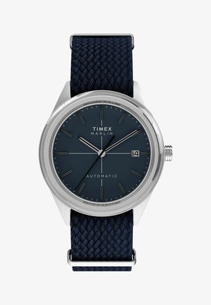 Automatické hodinky Timex Marlin s tmavomodrým ciferníkom, striebornými hodinovými markermi, zobrazením dátumu na pozícii 3 hodín a tmavomodrým tkaným textilným remienkom.