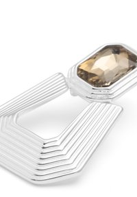 Broche geométrica de plata con detalles estriados y una gran piedra preciosa marrón facetada en la parte superior. Textura suave con un diseño angular.