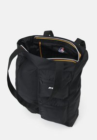 Borsa a tracolla nera in tessuto con due lunghe tracolle, chiusura con zip, tasche interne e tasca esterna con zip. Presenta un'etichetta con il logo.