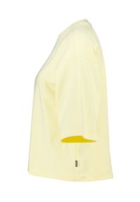 Light yellow short-sleeve crew neck t-shirt shown from side, with a small black tag near the hem on the left side.