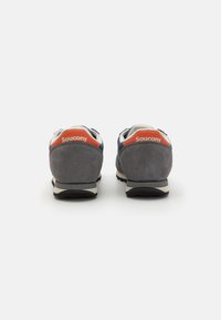 Grå semi-skinn løpesko med blå detaljer og oransje merking på hælen. Har en svart såle og en polstret krage for komfort.