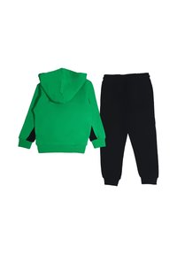Felpa con cappuccio verde con un accento nero, abbinata a pantaloni della tuta neri. Tessuto in cotone, polsini ed elastico in vita per una vestibilità comoda.