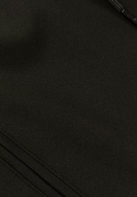 Zwarte stofstructuur met een gladde afwerking, met zichtbare naden en plooien, wat wijst op een zacht, flexibel materiaal.