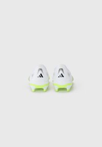 White soccer cleats with neon green accents, featuring a textured upper, pronounced heel, and black branded logo.