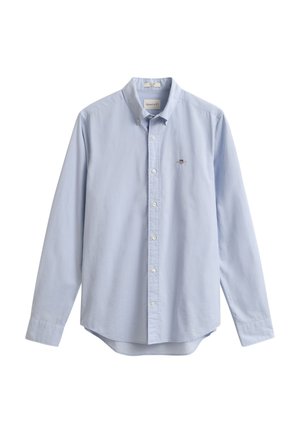 Chemise bleu clair à manches longues avec boutons, col et petit logo brodé sur la poitrine gauche.